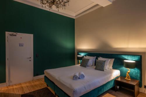 a bedroom with a large bed with a green wall at Hotel Onderbergen in Ghent