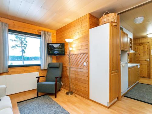 - une cuisine avec un réfrigérateur et une chaise dans la chambre dans l'établissement Holiday Home Huhmari 16 by Interhome, à Polvijärvi