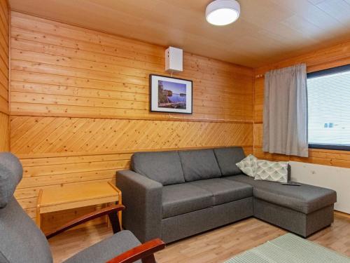 un salon avec un canapé et une chaise dans l'établissement Holiday Home Huhmari 15 by Interhome, à Polvijärvi