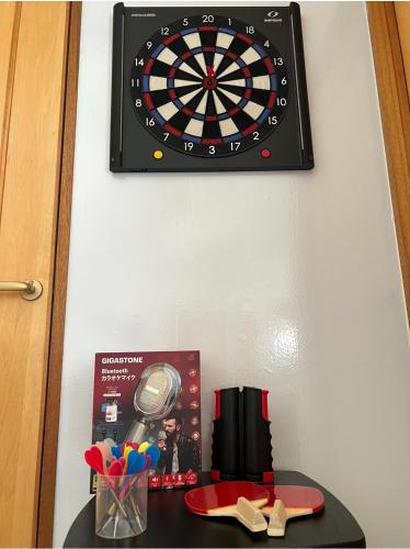 a dart board on a wall next to a table at Asahi House in Hiyakon