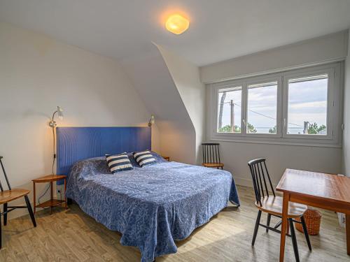 - une chambre avec un lit bleu, une table et des chaises dans l'établissement Apartment La Voilerie by Interhome, à Carnac