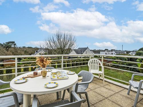 un patio avec une table et des chaises sur un balcon dans l'établissement Apartment Le Prat-2 by Interhome, à Guidel