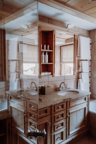 a bathroom with two sinks and a large mirror at Das Verwall - finest serviced apartments in Lech am Arlberg