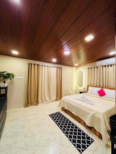 a bedroom with a large bed with a wooden ceiling at Coastal Water Cove Infinity Pool Villa in Alibag