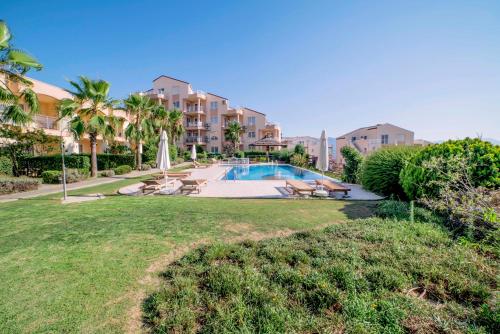 a resort with a swimming pool and palm trees at Unique Residence Hotel Golf and Spa in Soke