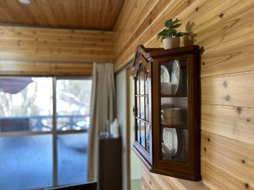 a wooden cabinet on the wall of a room with a window at SSK Mountain Base in Tsumagoi