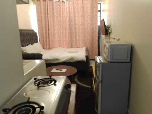 a small room with a stove and a bed at Traveler's Staycation II in Rungiri