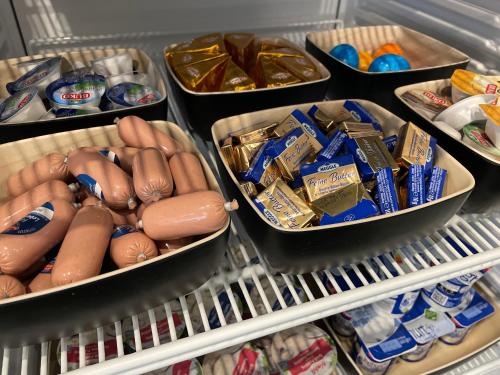 a refrigerator filled with hot dogs and other food at Hotel Elsen in Grevenbroich