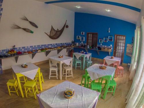 a restaurant with tables and chairs in a room at Pousada dos Corais in Itaúnas
