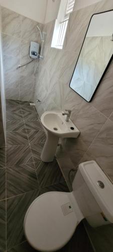 a bathroom with a toilet and a sink at Kamengo Cottages in Fort Portal