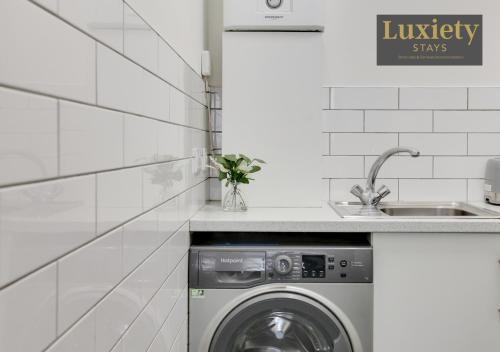 a washing machine in a kitchen next to a sink at Stylish Sunny Studio City Centre By Luxiety… in Southend-on-Sea