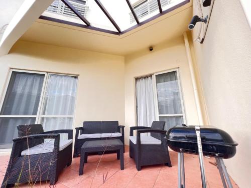 a patio with chairs and a grill and windows at Asahi House in Hiyakon