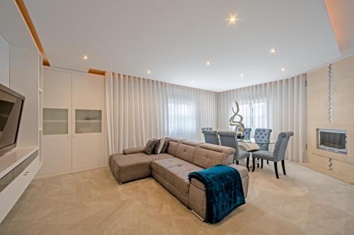 a living room with a couch and a dining room at Urbanização Casas Do Lago, Serra de Carnaxide in Amadora