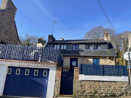 a house with a blue gate and a stone building at Maison de pêcheur in Perros-Guirec