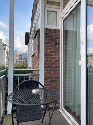 a table and chair on a balcony with a window at Hotel Elsen in Grevenbroich
