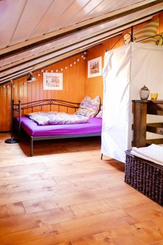 a bedroom with a purple bed in a room at Geographer`s Cottage II in Siegsdorf