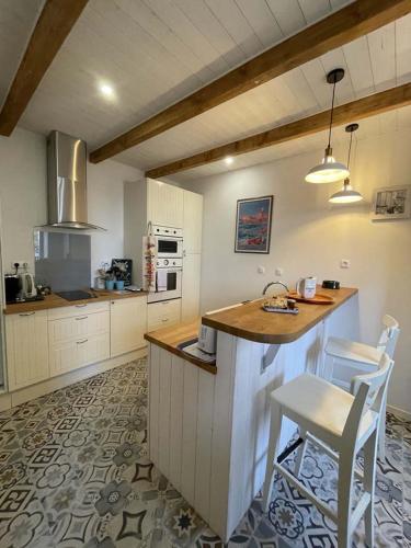 une cuisine avec un comptoir, une table et des chaises dans l'établissement Maison de pêcheur, à Perros-Guirec