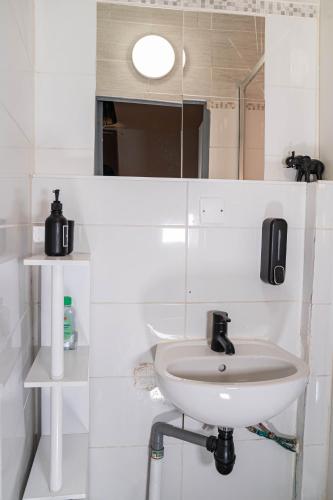 une salle de bain blanche avec un lavabo et un miroir dans l'établissement T2 Centre Ville à 2 min Gare St-Roch avec climatisation, à Montpellier