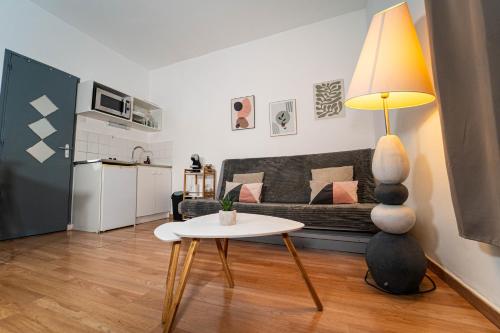 - un salon avec un canapé et une table avec une lampe dans l'établissement T2 Centre Ville à 2 min Gare St-Roch avec climatisation, à Montpellier