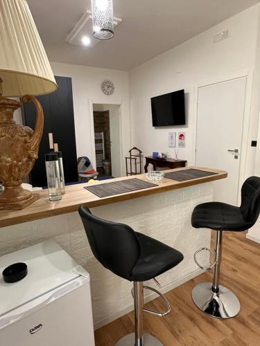 a kitchen with a counter and two chairs at a bar at Palmina's Apartments in Brindisi
