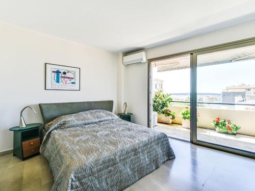 une chambre avec un lit et une grande fenêtre dans l'établissement Apartment Le Katia-2 by Interhome, à Cannes