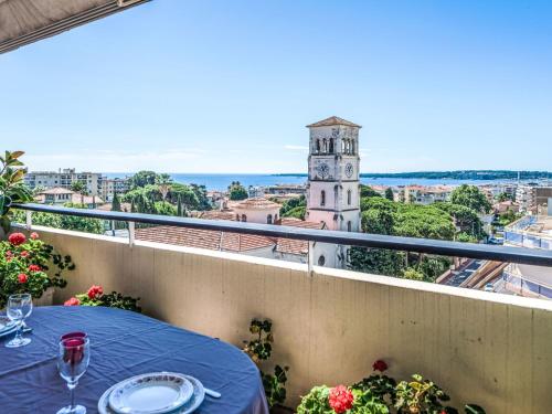 d'un balcon avec une table et une tour d'horloge. dans l'établissement Apartment Le Katia-2 by Interhome, à Cannes