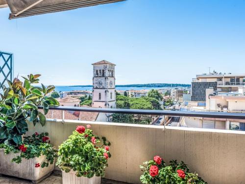 d'un balcon fleuri et d'une tour d'horloge. dans l'établissement Apartment Le Katia-2 by Interhome, à Cannes