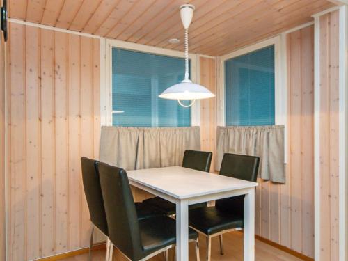 une salle à manger avec une table et des chaises blanches dans l'établissement Holiday Home Huhmari 21 by Interhome, à Polvijärvi