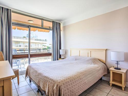 une chambre avec un lit et une grande fenêtre dans l'établissement Apartment Heliotel Marine-2 by Interhome, à Saint-Laurent-du-Var