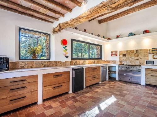 une grande cuisine avec des armoires et des comptoirs en bois dans l'établissement Holiday Home La Bastide Neuve by Interhome, à La Môle