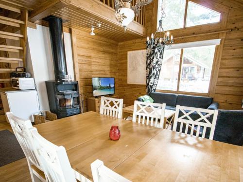a dining room with a table and a stove at Holiday Home Puolukka 2 by Interhome in Isnäs