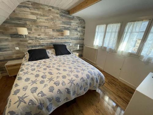 a bedroom with a bed and a stone wall at Maison de pêcheur in Perros-Guirec