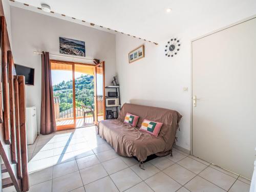 un salon avec un canapé et une porte coulissante en verre dans l'établissement Apartment Domaine Des Lauriers by Interhome, à Cavalaire-sur-Mer