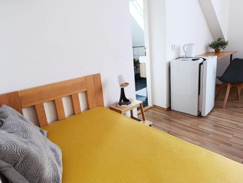 a bedroom with a bed and a refrigerator at Ubytování Pohoda in Třeboň