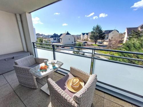 a balcony with a table and chairs and a view at Apartment Grand Balcon- Piscine et proche du Port by Interhome in Arzon