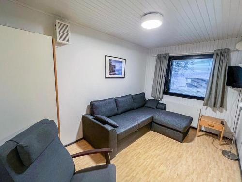 un salon avec un canapé, une table et une fenêtre dans l'établissement Holiday Home Huhmari 14 by Interhome, à Polvijärvi