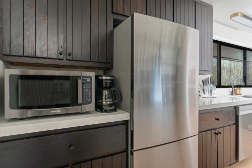 a kitchen with a stainless steel refrigerator and a microwave at Secluded Mountain View Getaway - Near Jackson Hole - BBQ, Patio Wildlife! in Wilson