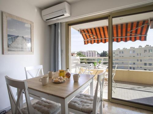une salle à manger avec une table et une vue sur un balcon dans l'établissement Apartment Cagnes Provencal by Interhome, à Cagnes-sur-Mer