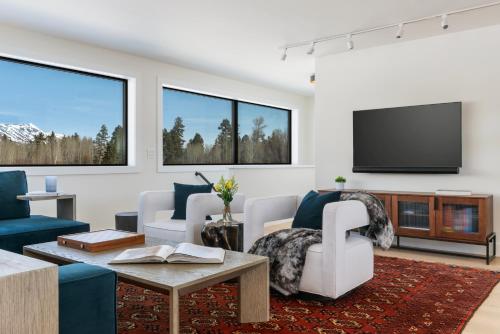 a living room with a couch and a tv at Secluded Mountain View Getaway - Near Jackson Hole - BBQ, Patio Wildlife! in Wilson
