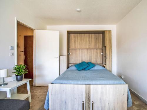 une chambre avec un lit avec des oreillers bleus dessus dans l'établissement Apartment Cagnes Provencal by Interhome, à Cagnes-sur-Mer