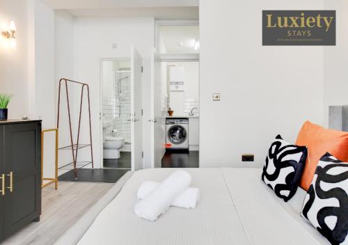 a bedroom with a large white bed with orange and black pillows at Chic & Stylish Studio City Centre Nr High St by Luxiety Stays in Southend-on-Sea