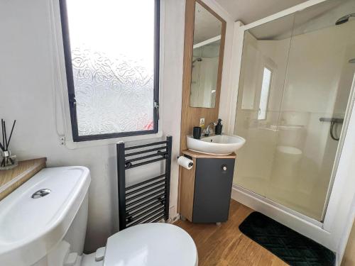 a bathroom with a white toilet and a sink at 6 Berth Caravan With Free Wi-Fi At Dovercourt Holiday Park In Essex Ref 44609C in Great Oakley