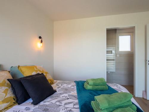 a bedroom with a bed with green towels on it at Holiday Home La Maison de Parrain by Interhome in Kerlouan