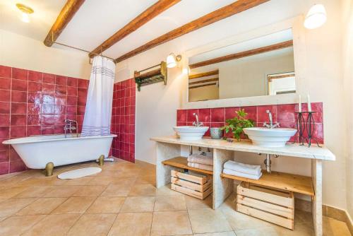 a bathroom with two sinks and a tub and red tiles at Casa Oliva by Kompas Villas in Čepljani