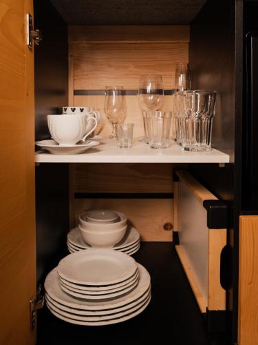 a cabinet filled with plates and glasses on a shelf at Cabana Jequitibá in Maria da Fé