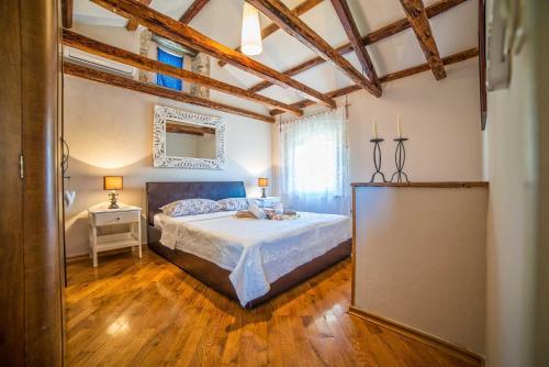 a bedroom with a bed in a room with wooden floors at Casa Oliva by Kompas Villas in Čepljani