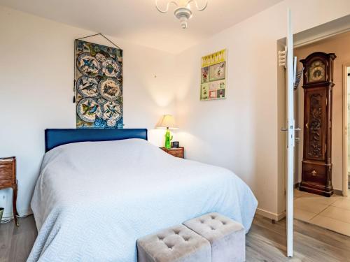 une chambre avec un grand lit avec une tête de lit bleue dans l'établissement Holiday Home Les Coquelicots by Interhome, à Blonville-sur-Mer