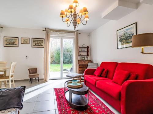 un salon avec un canapé rouge et une table dans l'établissement Holiday Home Les Coquelicots by Interhome, à Blonville-sur-Mer