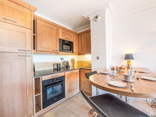 a kitchen with wooden cabinets and a wooden table at Apartment Le Domaine de la Baie-4 by Interhome in Cavalaire-sur-Mer