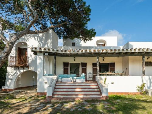 a white house with stairs and a tree at Villa La Conchiglia by Interhome in Villasimius